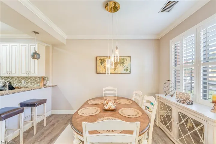 Dining area with crown molding and light wood-style floors
