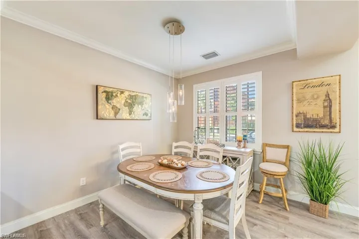 Dining space with ornamental molding and wood finished floors