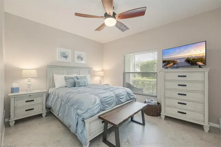 Bedroom with light tile patterned floors and a ceiling fan
