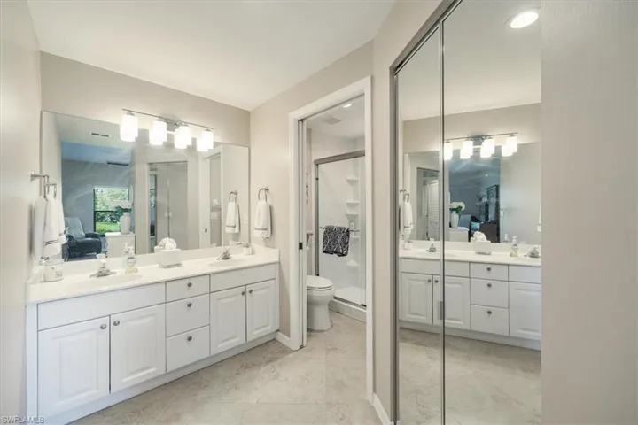 Bathroom with double vanity, ensuite bath, and a stall shower