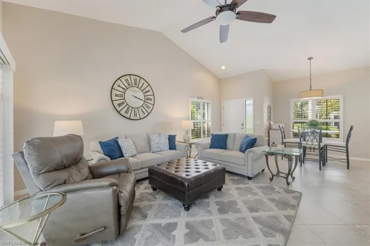 Living room featuring a ceiling fan, light tile patterned flooring, high vaulted ceiling, and recessed lighting