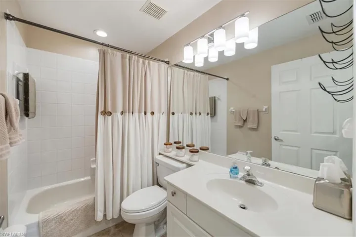 Full bathroom with vanity, shower / bath combo, and tile patterned floors