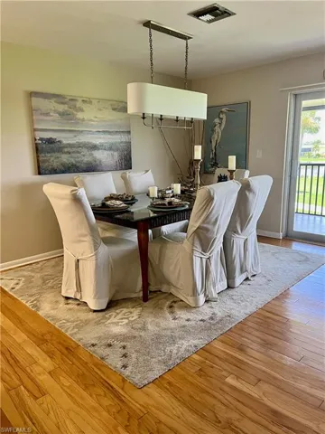 Dining area with Hardwood style floors and baseboards 6 person dining room table for entertaining