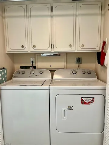 Laundry in residence featuring washing machine and dryer and cabinet space
