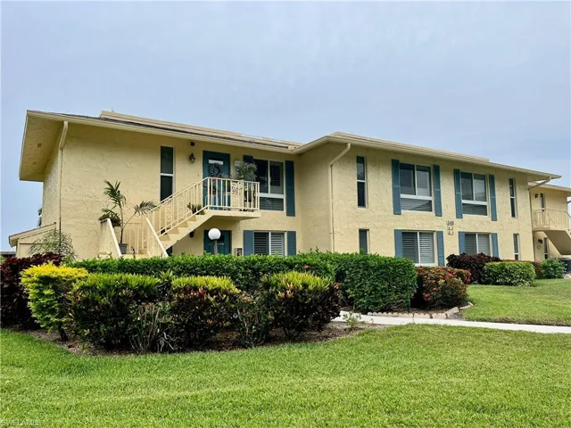 View of building exterior from the parking lot side with entrance on the second floor.