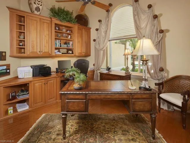 Generously proportioned den with solid wood cabinetry, beautiful wood floors and another gorgeous arched window