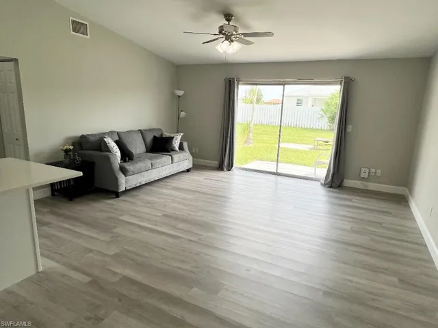 Living room featuring ceiling fan, vaulted ceiling, and light hardwood / wood-style flooring