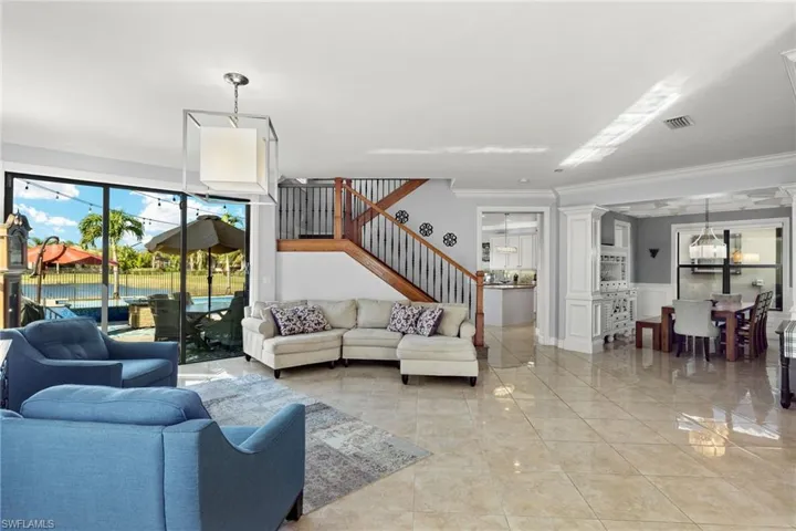 Living room featuring decorative columns and crown molding, Designer Lighting throuhgout.