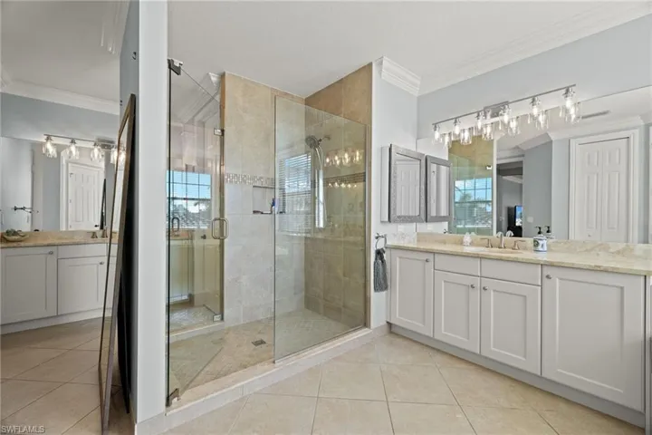 HIS Side and HERS side Bathroom featuring walk in shower, vanity, and a healthy amount of sunlight