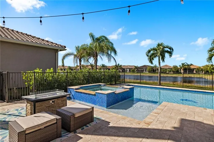 View of pool featuring a patio, an in ground hot tub, and a water view