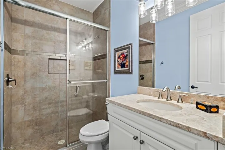 Jack N Jill Bathroom featuring an enclosed shower, vanity, and toilet
