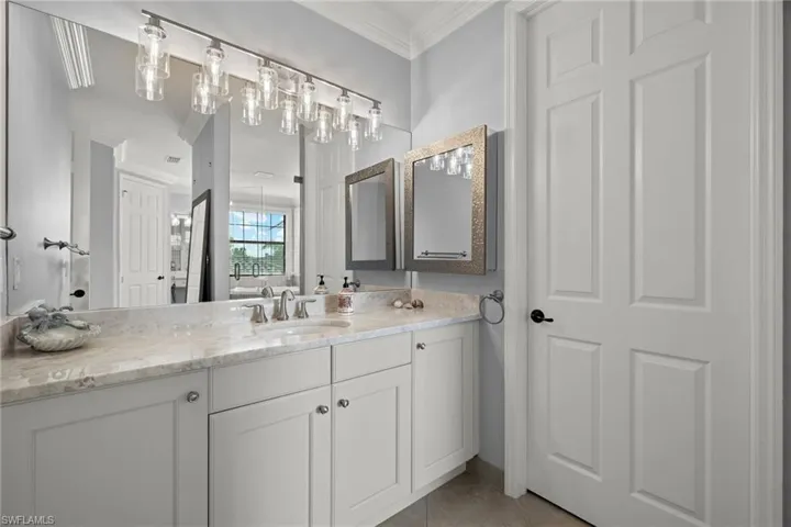 HIS side and HERS side Bathroom with vanity, tile patterned flooring, and crown molding