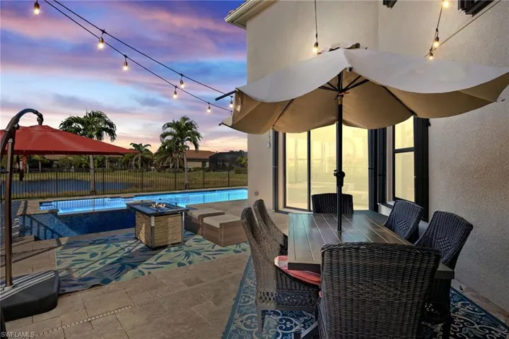 Patio terrace at dusk with a fenced in pool