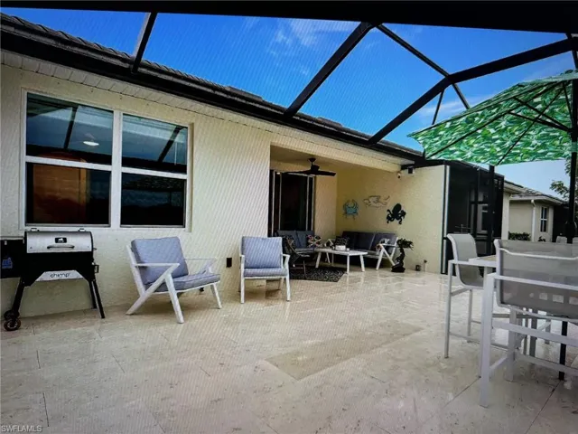 View of patio with ceiling fan, a lanai, and outdoor lounge area