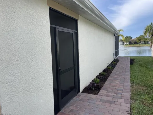 View of property exterior featuring a water view and a yard