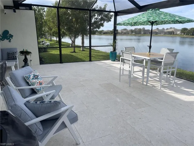 View of patio with a lanai and a water view