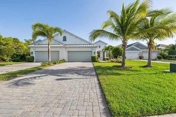View of front of property featuring a garage and a front lawn