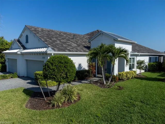 View of front facade featuring a front yard and a garage