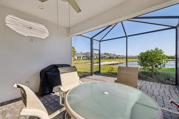 Sunroom / solarium with a water view and ceiling fan