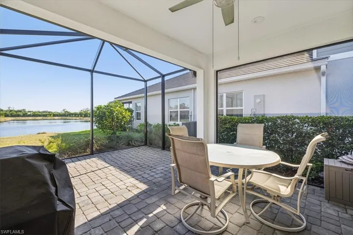 Sunroom / solarium featuring ceiling fan and a water view