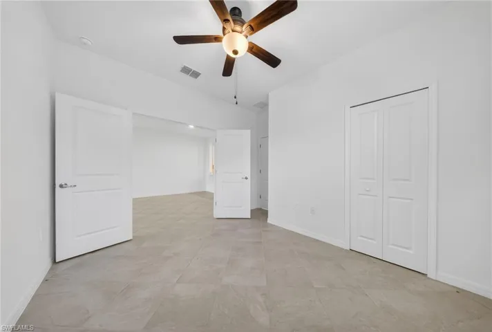 Unfurnished bedroom with ceiling fan and a closet