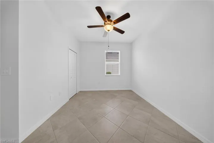 Spare room featuring a ceiling fan and light tile patterned floors