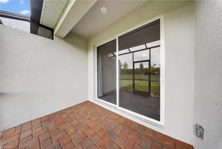 Property entrance featuring stucco siding and a patio area