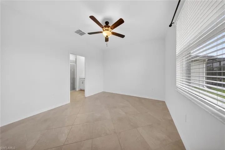 Empty room with a ceiling fan and baseboards