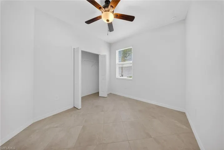 Unfurnished bedroom featuring ceiling fan and a closet