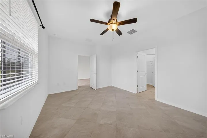 Unfurnished bedroom featuring a ceiling fan and baseboards