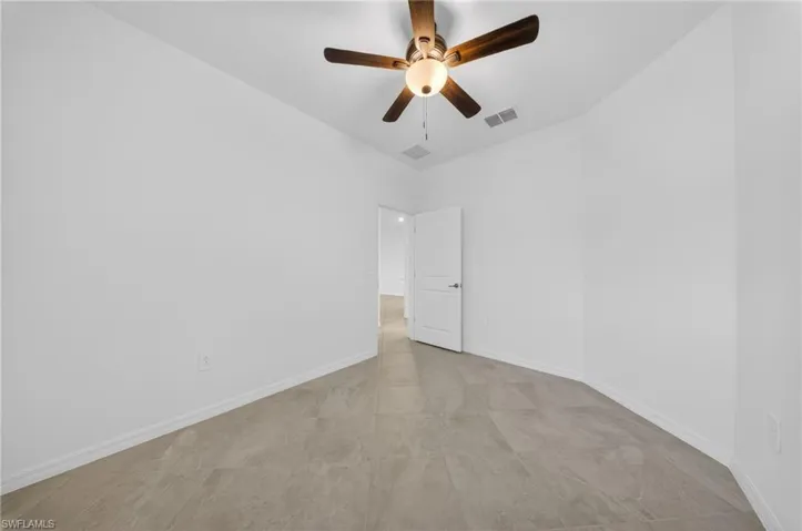 Spare room featuring baseboards and ceiling fan