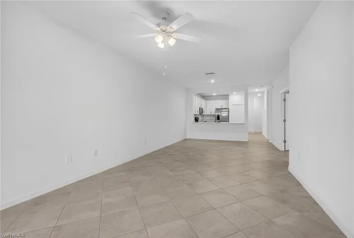 Unfurnished living room featuring a ceiling fan and light tile patterned flooring