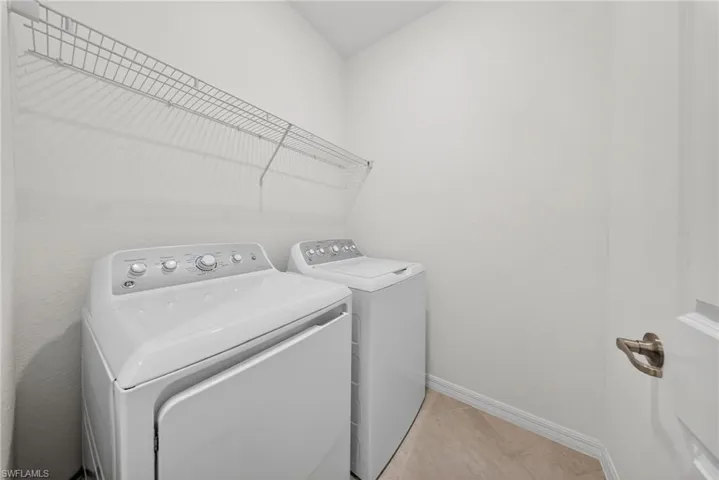 Laundry area with baseboards and separate washer and dryer