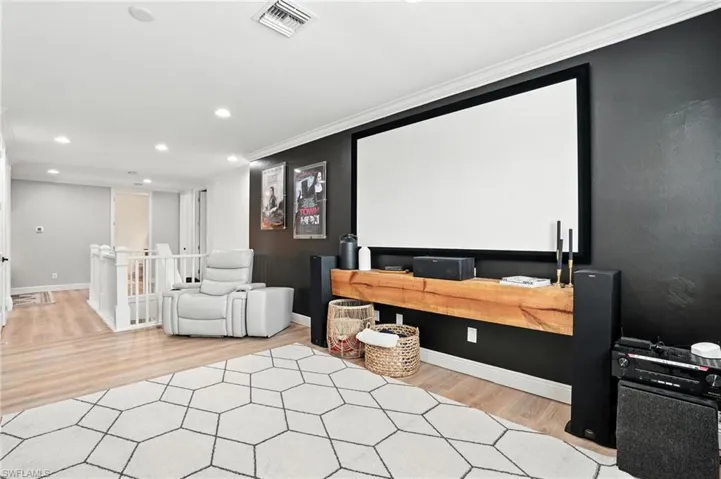 Home theater featuring crown molding, wood finished floors, and recessed lighting