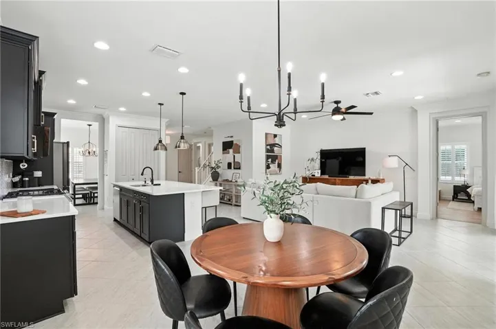 Dining area featuring a chandelier, crown molding, a ceiling fan, recessed lighting, and light tile patterned floors