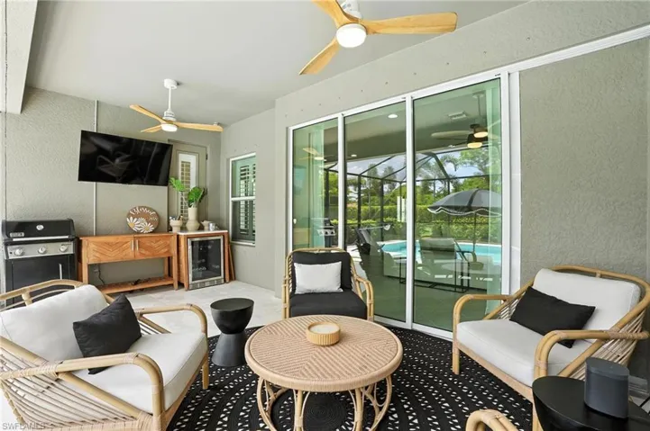Sunroom with a ceiling fan, wine cooler, and exterior kitchen
