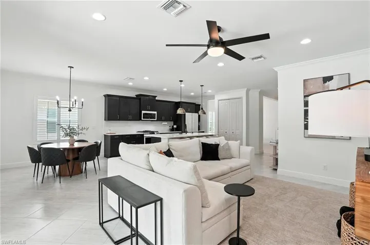 Living area featuring crown molding, a chandelier, recessed lighting, and ceiling fan
