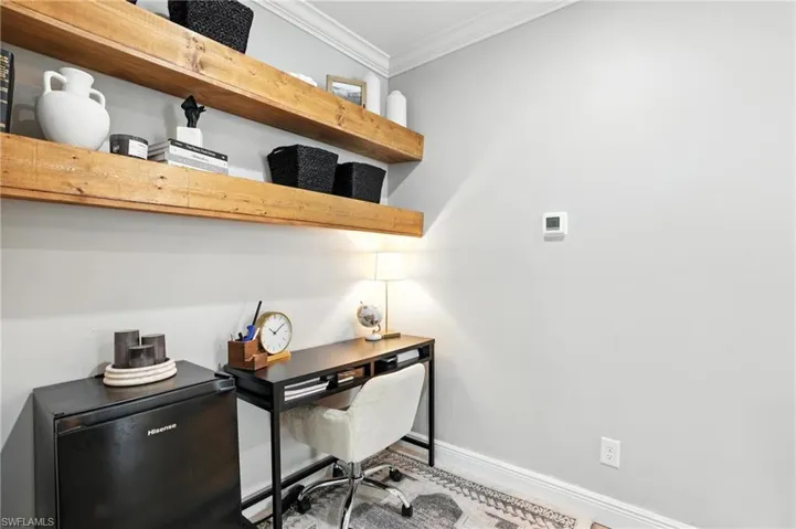 Home office featuring crown molding and baseboards