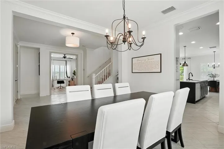 Dining area with a chandelier, crown molding, light tile patterned flooring, recessed lighting, and a ceiling fan