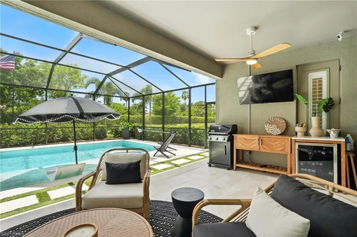 Swimming pool with a patio area, a ceiling fan, a grill, and screen enclosure