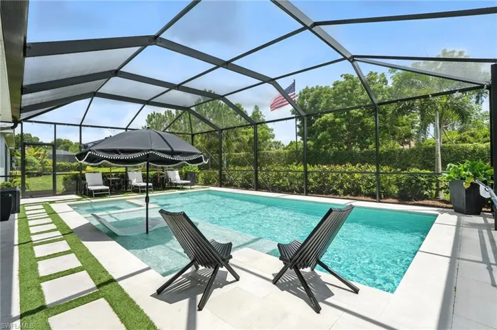 View of swimming pool featuring a patio and a pool with connected hot tub