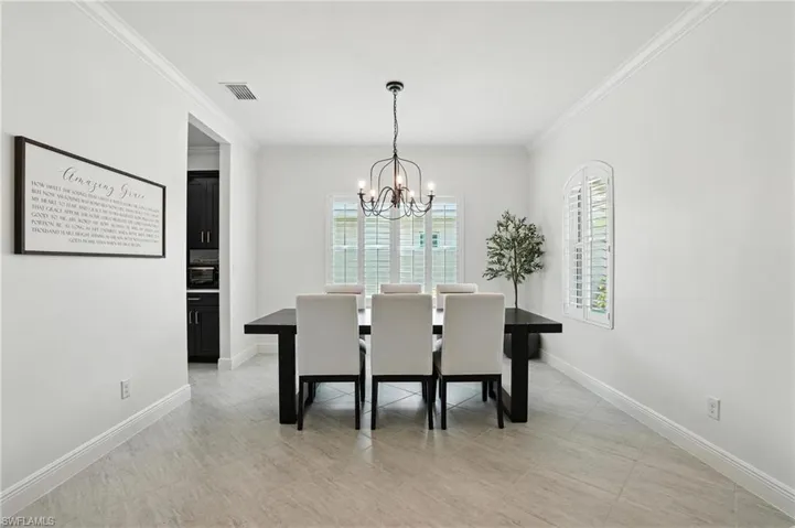 Dining space featuring a chandelier and crown molding