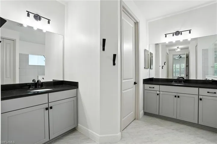 Full bath with two vanities and a tile shower
