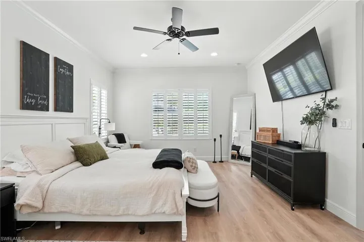 Bedroom with ornamental molding, light wood finished floors, recessed lighting, and a ceiling fan