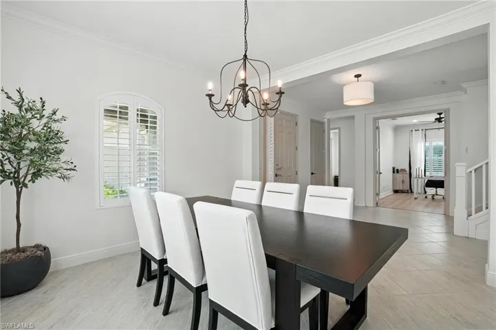 Dining space featuring a chandelier, ornamental molding, and light tile patterned flooring