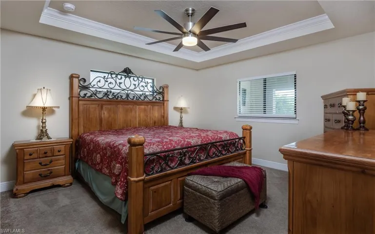 Bedroom featuring a trey ceiling ceiling fan, carpet floors, and crown molding