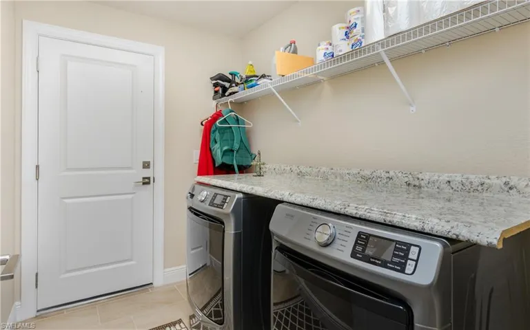 Laundry room featuring light tile patterned floors