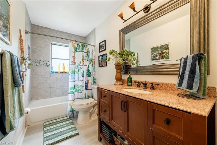 Full bathroom with vanity, toilet, and shower / bathtub combination with curtain