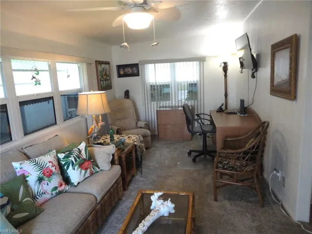 Carpeted  space featuring ceiling fan and plenty of natural light