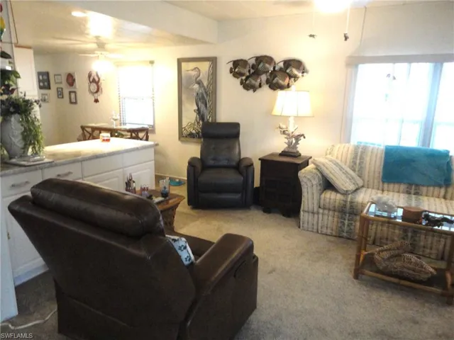 Carpeted living room with ceiling fan